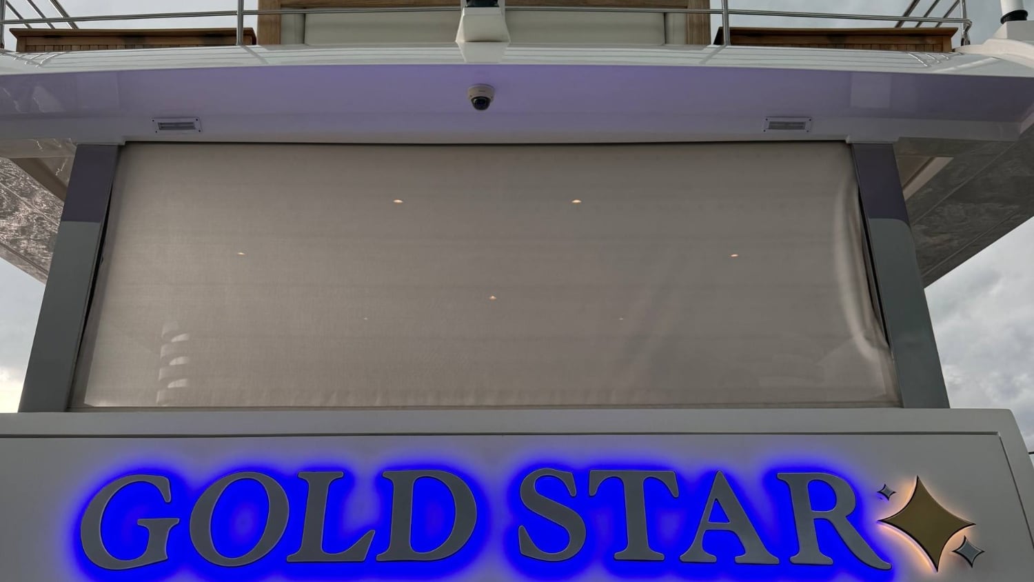 Finished GOLD STAR dimensional lettering with blue backlight in daylight